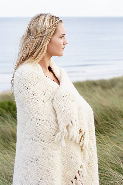 istock Young Woman Standing In Sand Dunes Wrapped Up Warm 148798918