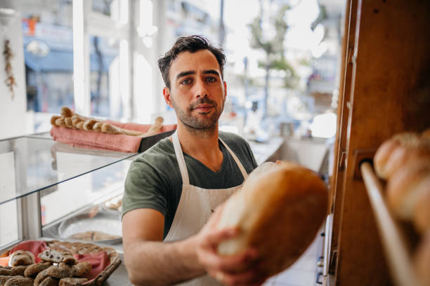 istock Baker man in bakery shop choosing bread 1487991580