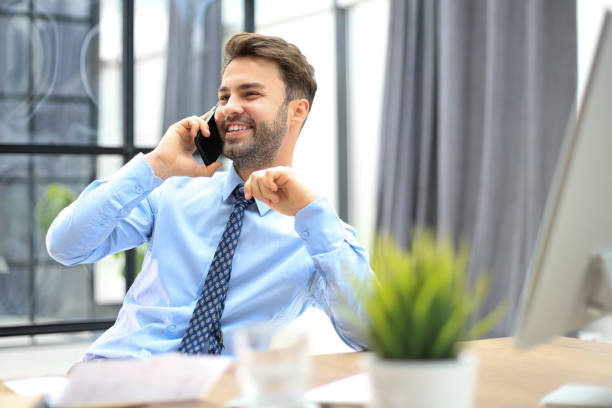 istock Handsome businessman in office talking on phone 1487993055