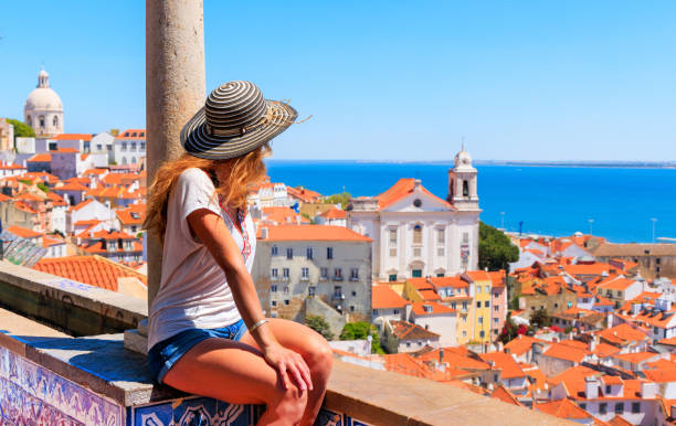 Mujer turista sentada en el balcón mirando la vista panorámica de la azotea de Lisboa- Portugal - foto de stock