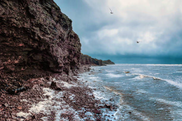 felsklippe über dem wasser mit einer gezeitenküste. meer felsen klippen im ozean. schöne meerestapete für tourismus und werbung. stürmische landschaft. - reef break stock-fotos und bilder