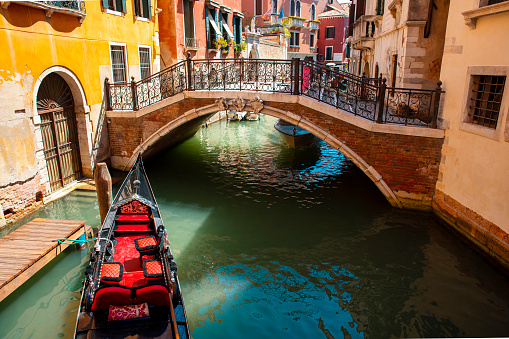 Beautiful water street with gondola boat and small bridge in Venice
