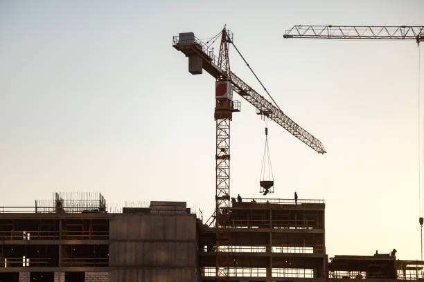 siluetta della gru industriale sulla costruzione della casa del cantiere al cielo blu. concetto di costruzione e ristrutturazione di edifici. gru industriali sul sito di creazione, veduta aerea. copia spazio di testo, banner - plan urban scene city life construction foto e immagini stock