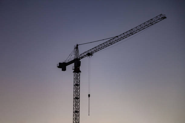 siluetta della gru industriale sul cantiere al cielo blu della sera. concetto di costruzione e ristrutturazione di edifici. gru industriale sul sito di creazione, sfondo. copiare lo spazio di testo dell'annuncio per il banner - plan urban scene city life construction foto e immagini stock