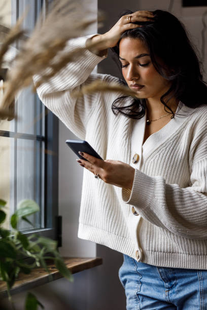 istock Worried young woman reading a text message via smart phone 1487997555