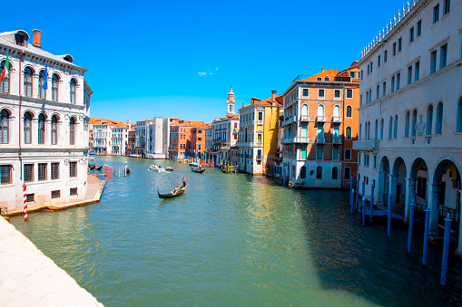 View on Grand Canal (Canal Grande) with gondola boats on the water. Beautiful old buildings along the waterfront. Dome of Basilica in the background. Venice, Italy. Copy space