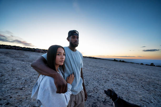 Portrait Cute Mixed Race Couple Posing on a Large Sandstone Formation at Dusk in Western Colorado Near Fruita and Grand Junction Portrait Cute Mixed Race Couple Posing on a Large Sandstone Formation at Dusk in Western Colorado Near Fruita and Grand Junction fruita colorado stock pictures, royalty-free photos & images