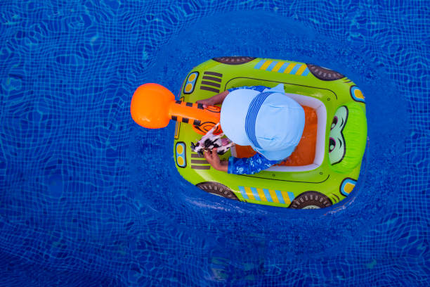 Pool turtle and other floats in a back garden pool. No people.