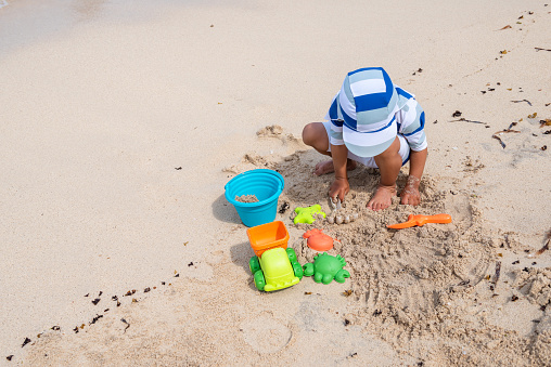 Little boy playing with his toys on the beach