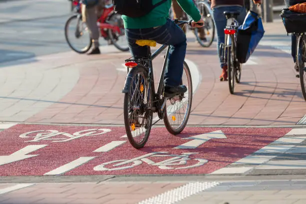 cyclists on red colored two-way bike path
