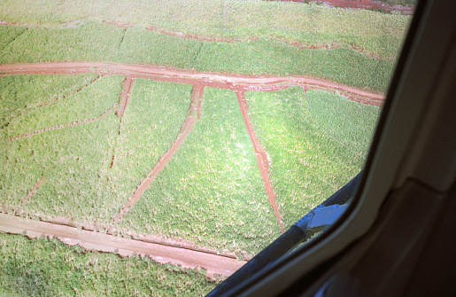 A vintage 1980s film photograph aerial view of lush Hawaiian rural farm and ranch land.