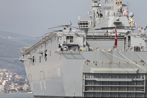TCG Anadolu, built in Sedef Shipyard in Istanbul, is 230 meters (754 feet) in length and 32 m (105 ft) in width, and has an area of 9,200 square meters (99,028 sq-ft).\n\nSix helicopters can land or take off simultaneously, while uncrewed combat aerial vehicles can also be deployed at the ship's flight deck.\n\nThe ship, with a full-fledged hospital and two operation rooms, can host around 1,200 staff.\n\nIt has a capacity to carry 13 tanks, 27 marine assault vehicles, six armored personnel carriers, 15 trailers, and 33 various vehicles.