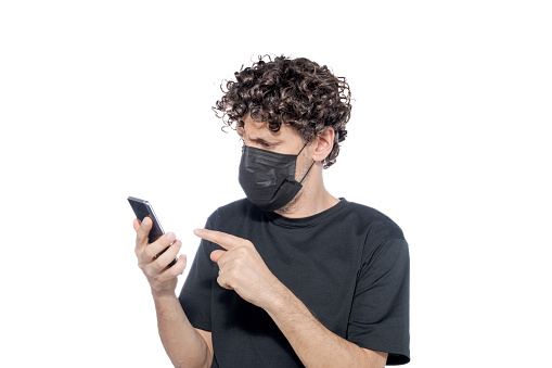 Middle-aged man in a black cover-up looking at his smartphone, on a white background.