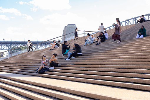 Sydney, Australia - May 05, 2023: Bennelong Point Opera House, Sydney, people enjoying sunny day on steps of the Sydney Opera House