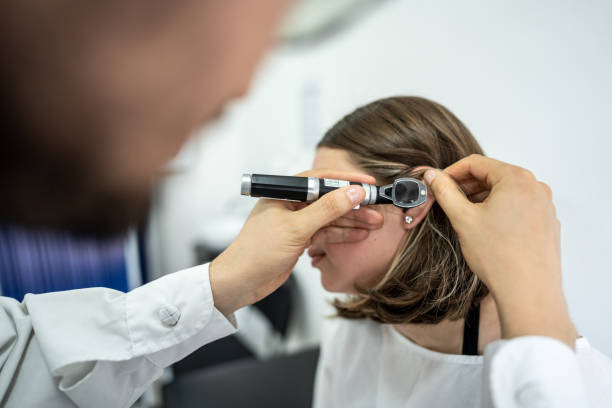 medico / otorinolaringoiatra che utilizza un otoscopio nell'orecchio di un paziente presso la clinica medica - esame otorino foto e immagini stock