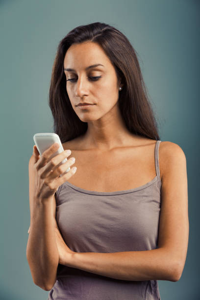 istock Woman, serious, upset at cellphone 1488028197
