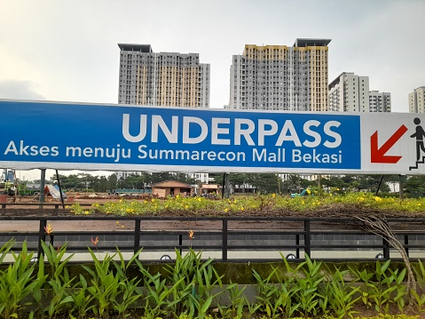 bekasi, indonesia - 6 may 2023 : underpass signboard in the business area of ​​Summarecon Mall Bekasi. background park concept, outdoor, cityscape, tower, apartment, town, downtown, housing, resident