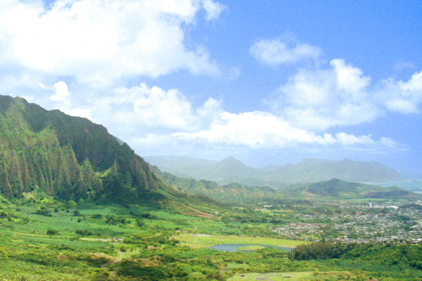 Vintage film photograph of the clouds and mist cover Oahu's rugged terrain, as seen from Nuʻuanu Pali lookout above Kaneohe, Hawaii.