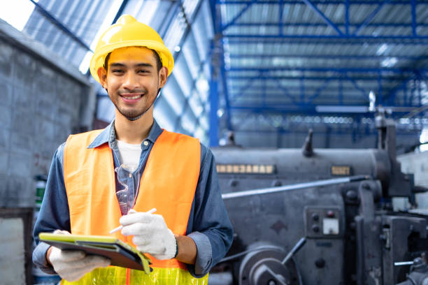 istock Professional industry engineers partner looking at camera and smile in factory.Engineer man wearing safety helmet working and checking machine. 1488062458