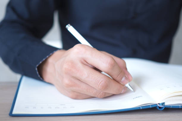 istock Businessmen write information in the book. 1488062516