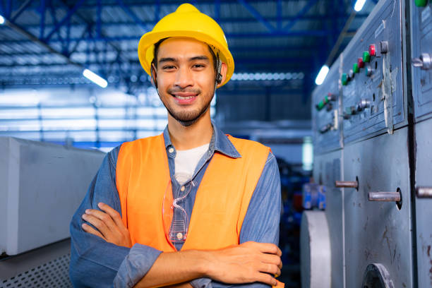 istock Professional industry engineers partner looking at camera and smile in factory.Engineer man wearing safety helmet working and checking machine. 1488062525