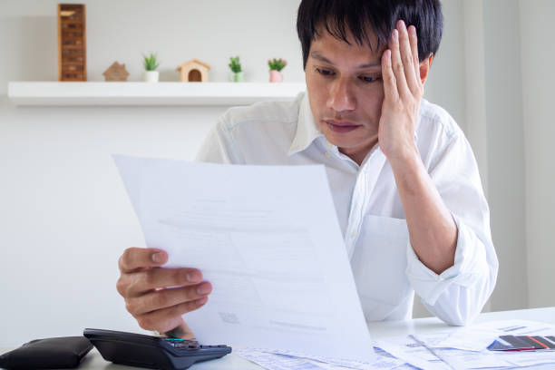 istock Asian men are stressed about debt problems. Men are worried about bills that must be paid monthly. Debt concepts, financial problems 1488066661