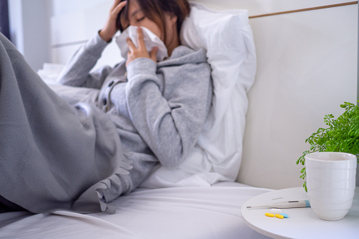 sick woman with a headache sitting under blanket, female sneezing and runny nose with seasonal influenza, allergic, high fever and influenza, resting, virus, coronavirus, feel illness, respiratory