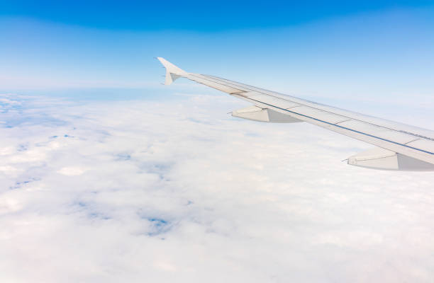 istock View from the airplane window at a beautiful cloudy sky and the airplane wing 1488069545