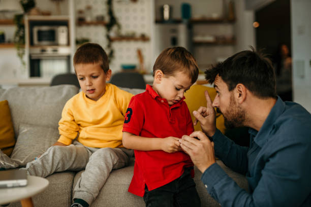 istock Father spending time with kids at home and telling them not to use a mobile phone that much. 1488069608