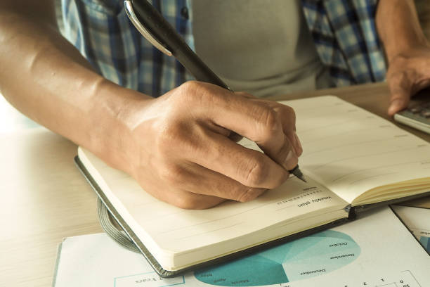 istock Hand written to the book concept. Man hand catch pen Take notes on the book. 1488071208