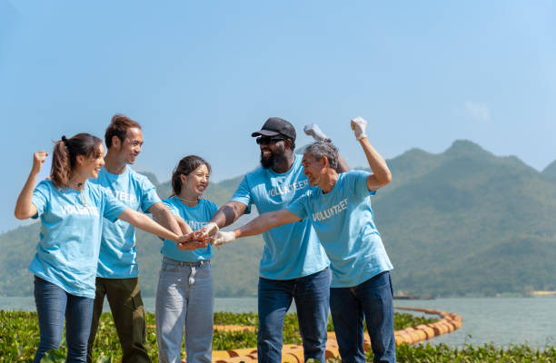 istock Group of happy volunteers joining hands stack together and raising hands with smile 1488071887