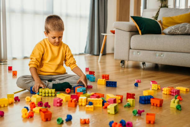 istock A little boy playing with his colorful cubes on the floor. 1488072124