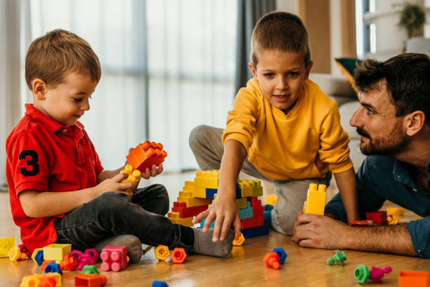 istock Father hugging and playing with his two sons at home. 1488072387