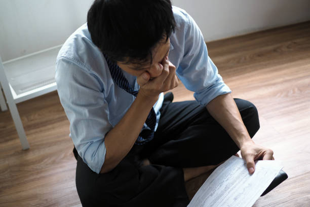 istock Asian businessmen are stressed with the documents held in their hands. 1488073293