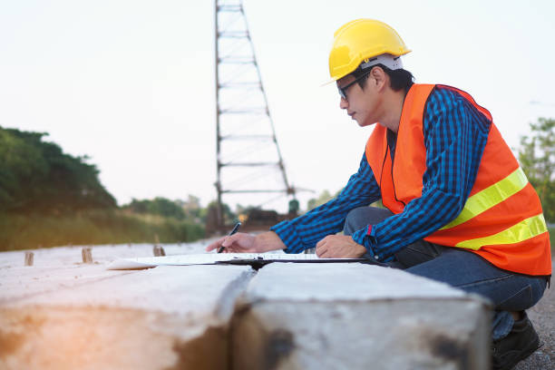 istock Engineers are reading the blueprint that is placed on piles in the construction area and the back has cranes. Building contractor concept 1488073294