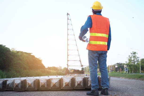 istock The engineer holds a blueprint in his hand, looking at the crane in the construction area. Building contractor concept 1488073295