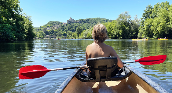 teenager paddling in french river on canoe- Dordogne