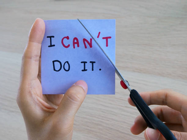 istock A woman's hand is holding a note with the message she wrote when she did not intend. And now she uses the scissors to cut off the letter T because she was inspired by something. 1488074759