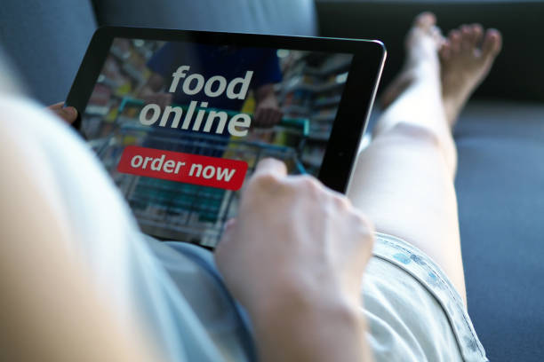 istock Women use tablets to order food online while lying on the couch at home. 1488074802