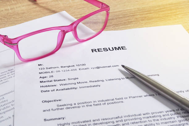 Resume applications on wooden desk. Pending applications from the management.