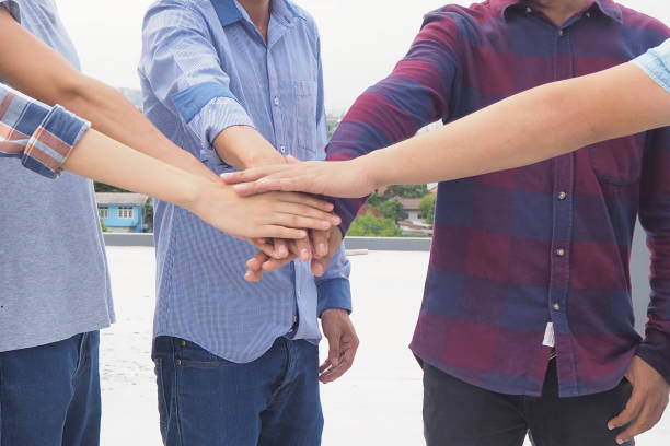 istock Young people hold hands Colleagues show their unity and teamwork. 1488079424