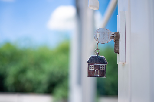 The house key for unlocking a new house is plugged into the door. Concept of rented house , buy or selling home.