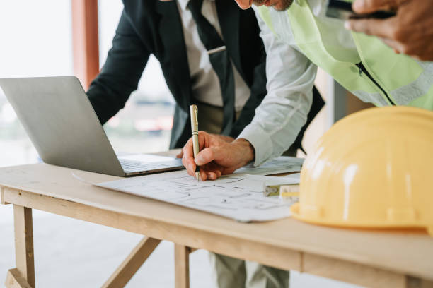 istock multi ethnic engineer brainstorming and measuring for cost estimating on blueprint and floor plan drawings about design architectural and engineering for houses and buildings 1488079807