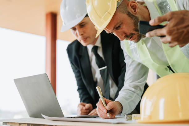 istock multi ethnic engineer brainstorming and measuring for cost estimating on blueprint and floor plan drawings about design architectural and engineering for houses and buildings 1488079852