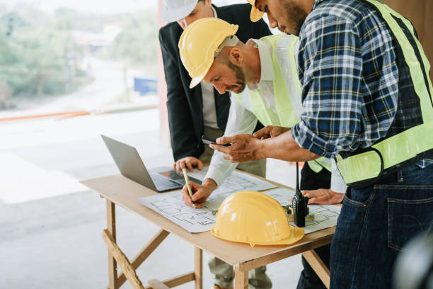 istock multi ethnic engineer brainstorming and measuring for cost estimating on blueprint and floor plan drawings about design architectural and engineering for houses and buildings 1488079900