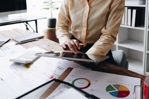 istock businesswoman in a black suit inside the office using tablet computer, audit paperwork for customers to contact, business people concept. 1488081466