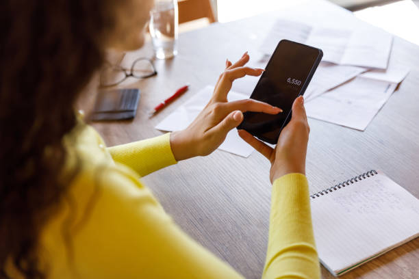 istock Young woman using a calculator on her smart phone when sorting out her home finances 1488082473