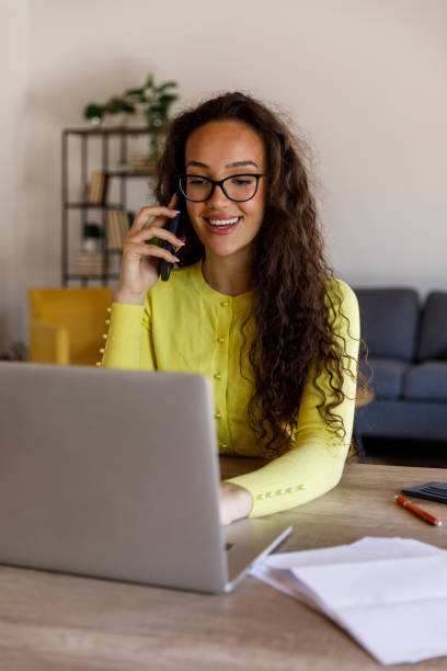 istock Smart young woman sitting at dining table, using laptop when managing home finances 1488083905