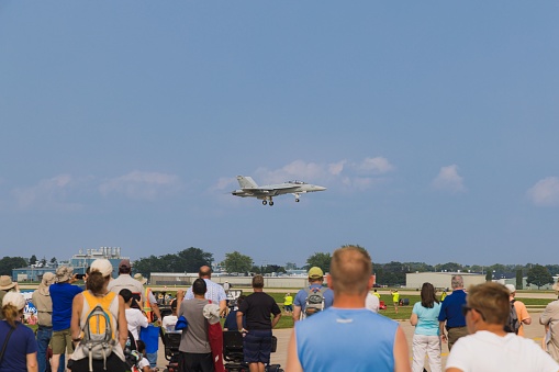 Oshkosh, United States – July 29, 2021: An audience of onlookers observe Boeing EA-18G fighter jet landing at EAA AirVenture