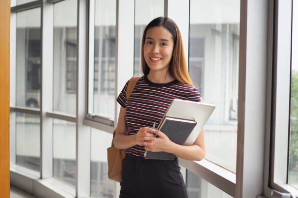 istock Beautiful female student with a book in high school or university 1488085041